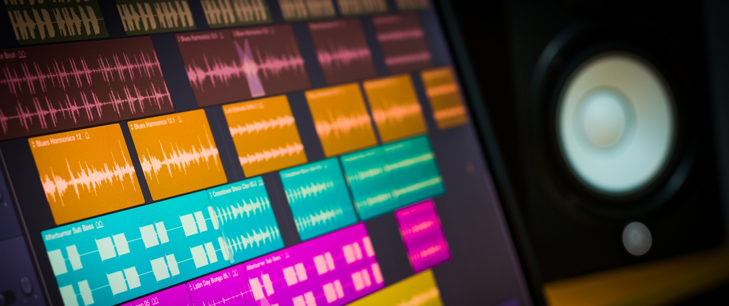 colorful digital waveform on computer monitor and studio speakers for sound recording concept
