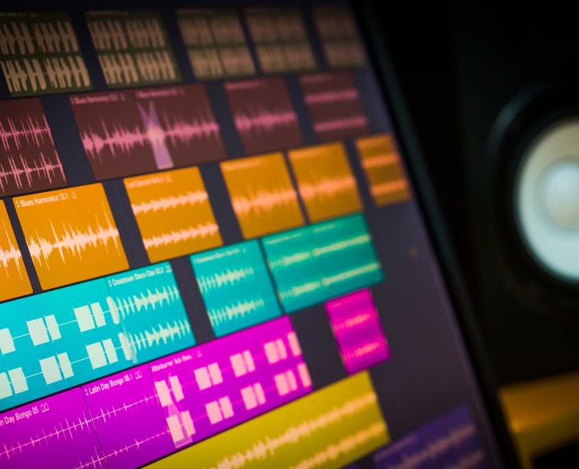 colorful digital waveform on computer monitor and studio speakers for sound recording concept